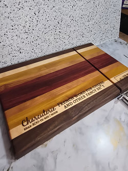 modern handcrafted wooden cheese board made from walnut, maple, rosewood, red heart and yellow heart, built in silver cheese slicer, perfect for charcuterie, cheese, and appetizers. Laser engraved with the phrase "charcuterie french word for cheese and other fancy shit"