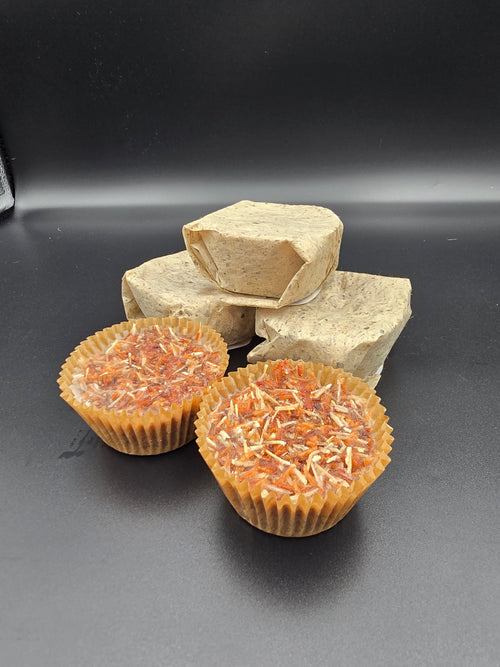 A close-up of Lathe Nights fire starters made from natural wood shavings and paraffin wax, packaged in small paper cups, ready to light a campfire or fireplace