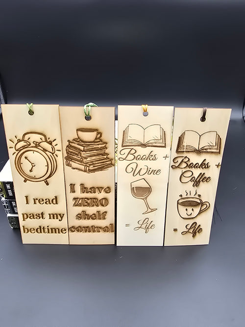A collection of 4 laser engraved wooden bookmarks with colorful tassels that measure 6" x 2", standard bookmark size. Features laser engraved phrases that read "I read past my bedtime" "i have zero shelf control" "books plus wine equals life" and "books plus coffee equals life"