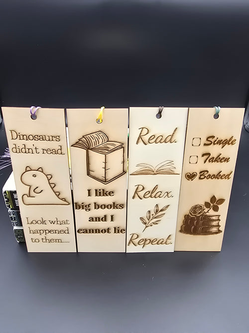 A collection of 4 laser engraved wooden bookmarks with colorful tassels that measure 6" x 2", standard bookmark size. Features laser engraved phrases that read "dinosaurs don't read. Look what happened to them." "I like big books and I cannot lie" "read. relax. repeat." and "Single. Taken. Booked."