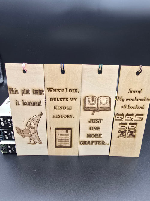 A collection of 4 laser engraved wooden bookmarks with colorful tassels that measure 6" x 2", standard bookmark size. Features laser engraved  sayings such as "This plot twist is bananas" When I die, delete my kindle history" "just one more chapter" and "Sorry my weekend is all booked"