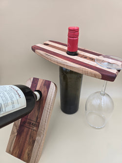 Wine bottle caddy and wine balancer, made of mahogany, maple, and padauk hardwoods, made by Lathe Nights Woodworking
