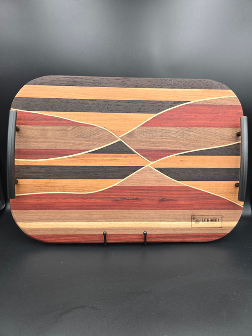 Wooden cutting board with a geometric pattern on a black background made with walnut maple padauk wenge and cherry