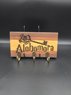 Wooden key hook laser engraved with "alohomora" made from walnut mahogany and yellow heart hardwoods, with three (3) gold hooks