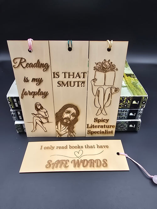 A collection of 4 laser engraved wooden bookmarks with colorful tassels that measure 6" x 2", standard bookmark size. Adult themed laser engraved phrases that read "reading is my foreplay" "is that smut" "spicy literature specialist" "i only read books that have safe words" 