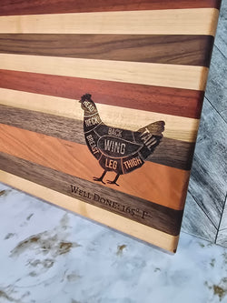 handcrafted wooden cutting board, made using walnut, cherry, red heart, and maple. laser engraved diagram of chicken cuts