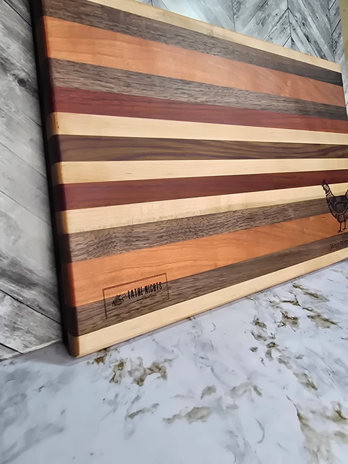 handcrafted wooden cutting board, made using walnut, cherry, red heart, and maple. laser engraved diagram of chicken cuts