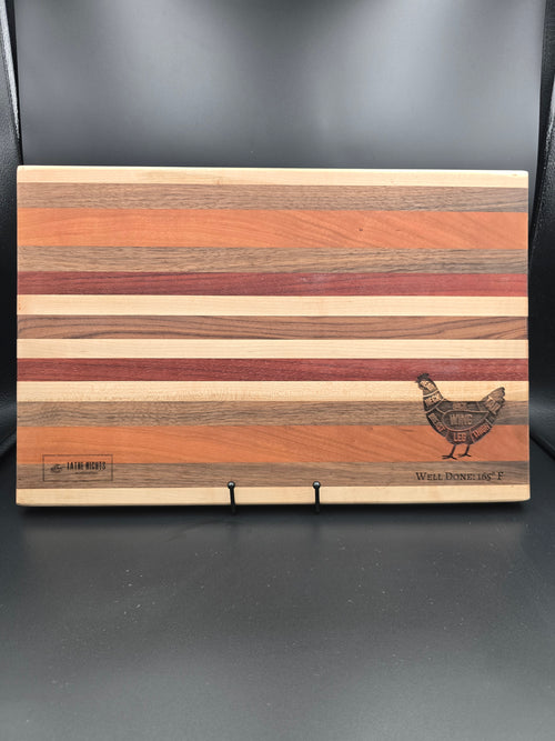 handcrafted wooden cutting board, made using walnut, cherry, red heart, and maple. laser engraved diagram of chicken cuts