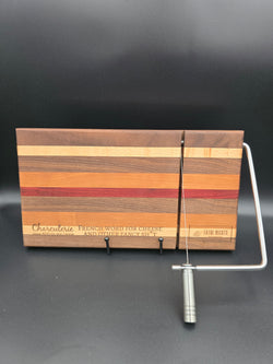 modern handcrafted wooden cheese board made from walnut, maple, cherry and padauk, built in silver cheese slicer, perfect for charcuterie, cheese, and appetizers. Laser engraved with the phrase "charcuterie french word for cheese and other fancy shit"