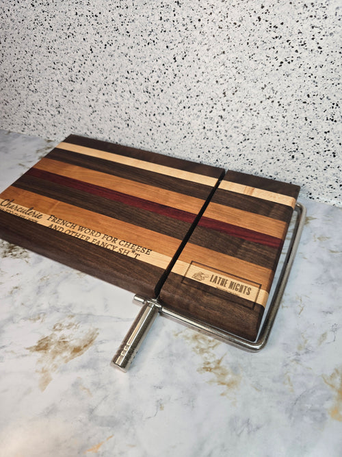 modern handcrafted wooden cheese board made from walnut, maple, cherry and padauk, built in silver cheese slicer, perfect for charcuterie, cheese, and appetizers. Laser engraved with the phrase "charcuterie french word for cheese and other fancy shit"