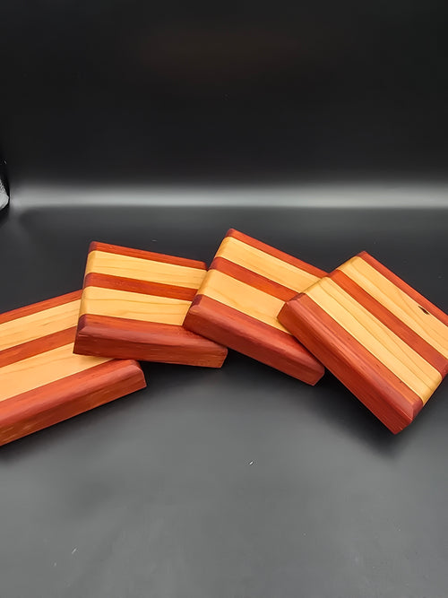 Set of 4 square wooden coasters, made using padauk and cherry natural hardwoods. Features non-slip rubber feet